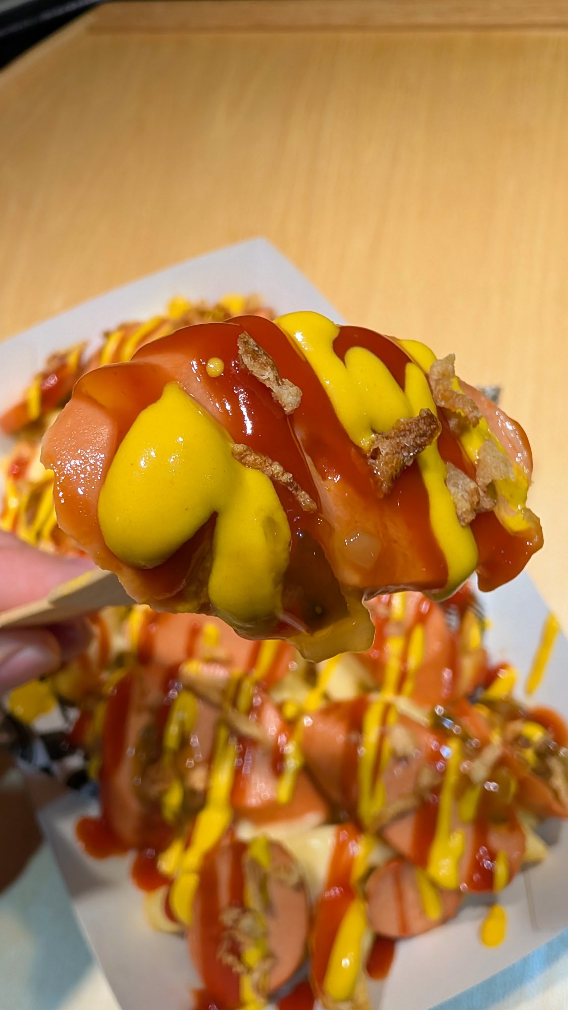 Stick close-up of a sliced Moving Mountains hot dog with ketchup, mustard and relish